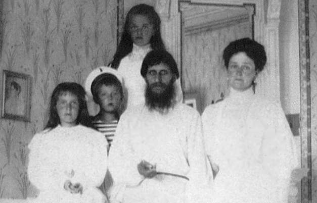 Caryca Aleksandra z dziećmi w towarzystwie Rasputina. Zdjęcie wykonano w 1908 roku (domena publiczna).
