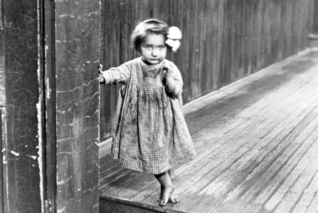 Fotografia Lewisa H. Hine'a zatytułowana: "Mała sierota Anne w zakładzie w Pittsburghu". Zdjęcie z 1909 roku.