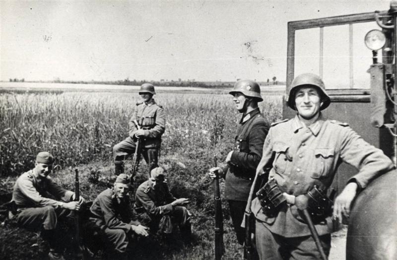 Uśmiechnięci niemieccy żandarmi na zdjęciu z 1943 roku, tuż przed pacyfikacją jednej z polskich wsi (domena publiczna).