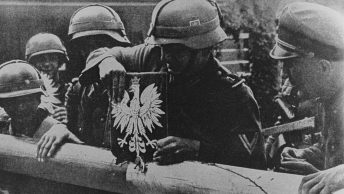 Niemieccy żołnierze zrywają polskie godło ze szlabanu granicznego