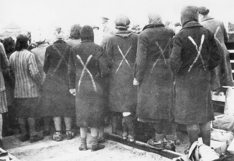 Były więźniarki KL Ravensbrück na zdjęciu z kwietnia 1945 roku. Biały krzyż oznaczał, że były one osadzonymi, mimo że nie otrzymały pasiaków (domena publiczna).