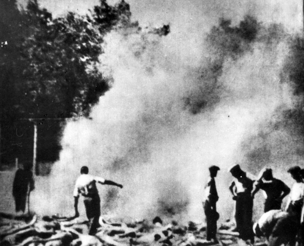 Członkowie Sonderkommando z Auschwitz-Birkenau palący zwłoki pomordowanych (domena publiczna).