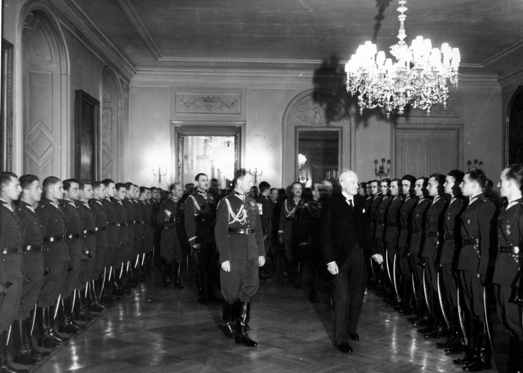 Nowo mianowani podporucznicy u prezydenta RP Ignacego Mościckiego na Zamku Królewskim w Warszawie. Zdjęcie z 1936 roku (domena publiczna).