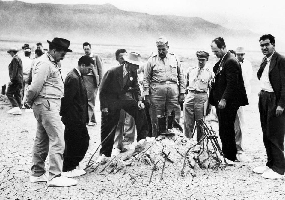 Zdjęcie z 9 września 1945 roku, na którym grup naukowców i wojskowych ogląda to co zostało z wieży, na której nastąpiła eksplozja (domena publiczna).