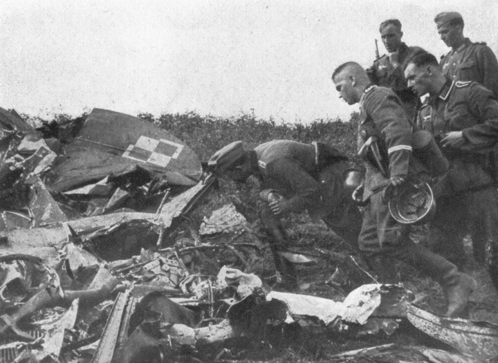 Niemieccy żołnierze oglądają wrak polskiego samolotu (domena publiczna).