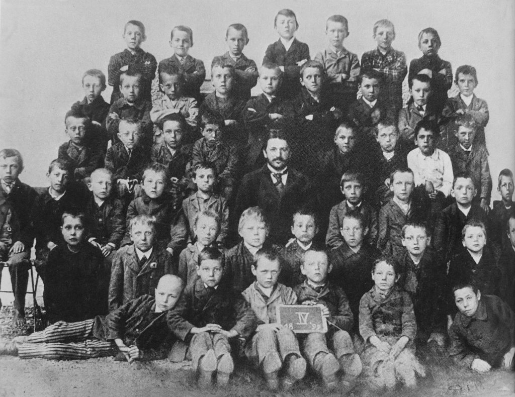 Dziesięcioletni Adolf (stoi w środku w ostatnim rzędzie) wraz z klasą. Zdjęcie z 1899 roku (domena publiczna).
