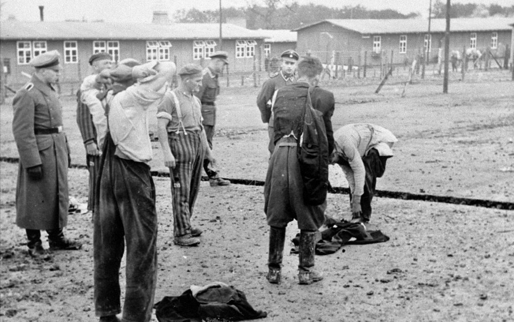 Nowoprzybyli więźniowie KL Buchenwald zdejmują cywilną odzież (domena publiczna).