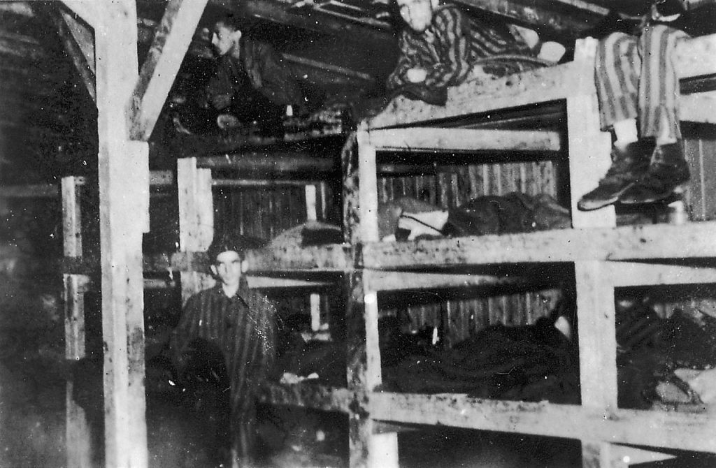 Więźniowie KL Buchenwald w jednym z baraków. Zdjęcie wykonane po wyzwoleniu obozu ( Jules Rouard/CC BY-SA 3.0).).