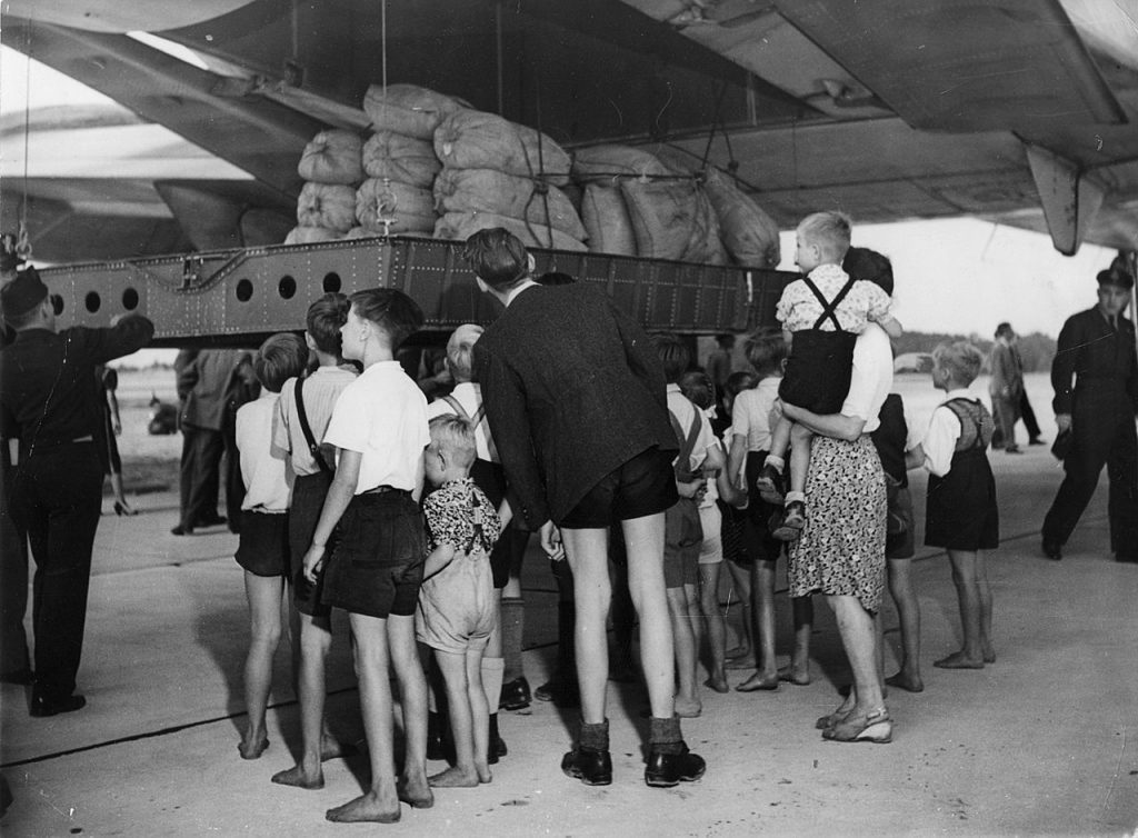 Rozładunek 20 ton mąki dostarczonej na pokładzie C-74 Globemaster. Zdjęcie wykonane 19 sierpnia 1948 roku (domena publiczna).