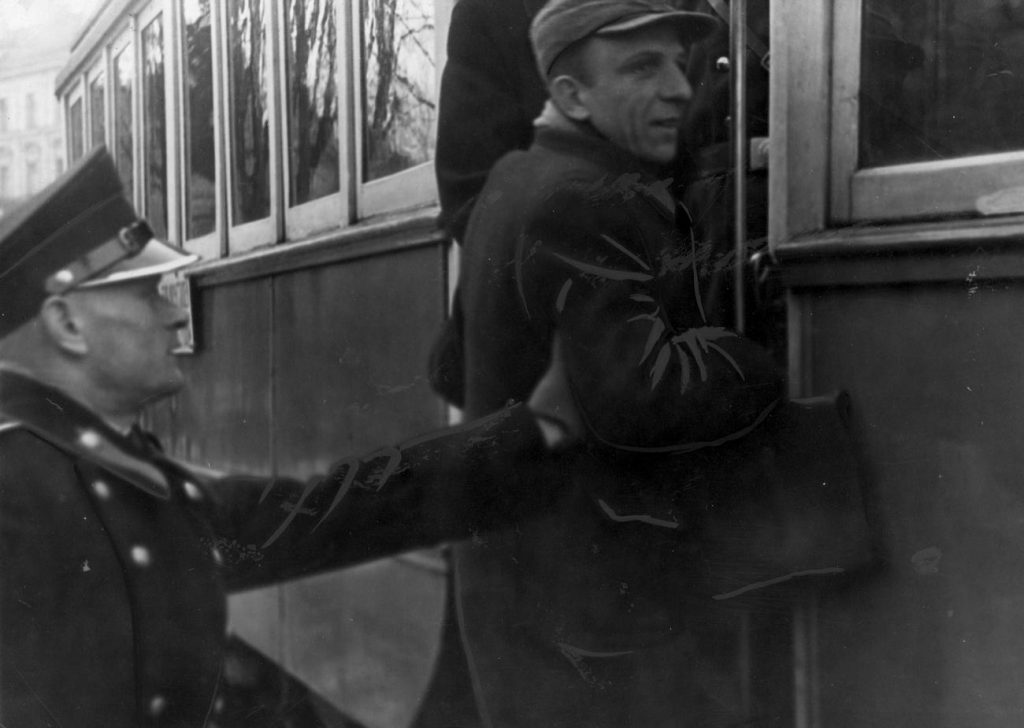Zdaniem Hempla od 20 do nawet 30 granatowych policjantów współpracowało z podziemiem. Na zdjęciu funkcjonariusz zatrzymuje mężczyznę wskakującego do tramwaju (domena publiczna).