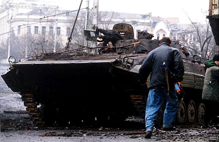 Czeczeński bojownik obok zniszczonego rosyjskiego BMP-2. Zdjęcie wykonane w styczniu 1995 roku (Michaił Ewstafielew/CC BY-SA 3.0).