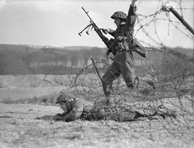 Żołnierze oddziału Commando trenujący pokonywanie ogrodzeń z drutu kolczastego (domena publiczna).