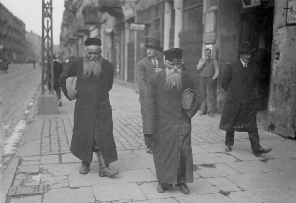 Dwaj Żydzi idący ulicą Nalewki w Warszawie. Zdjęcie z okresu międzywojennego (domena publiczna).