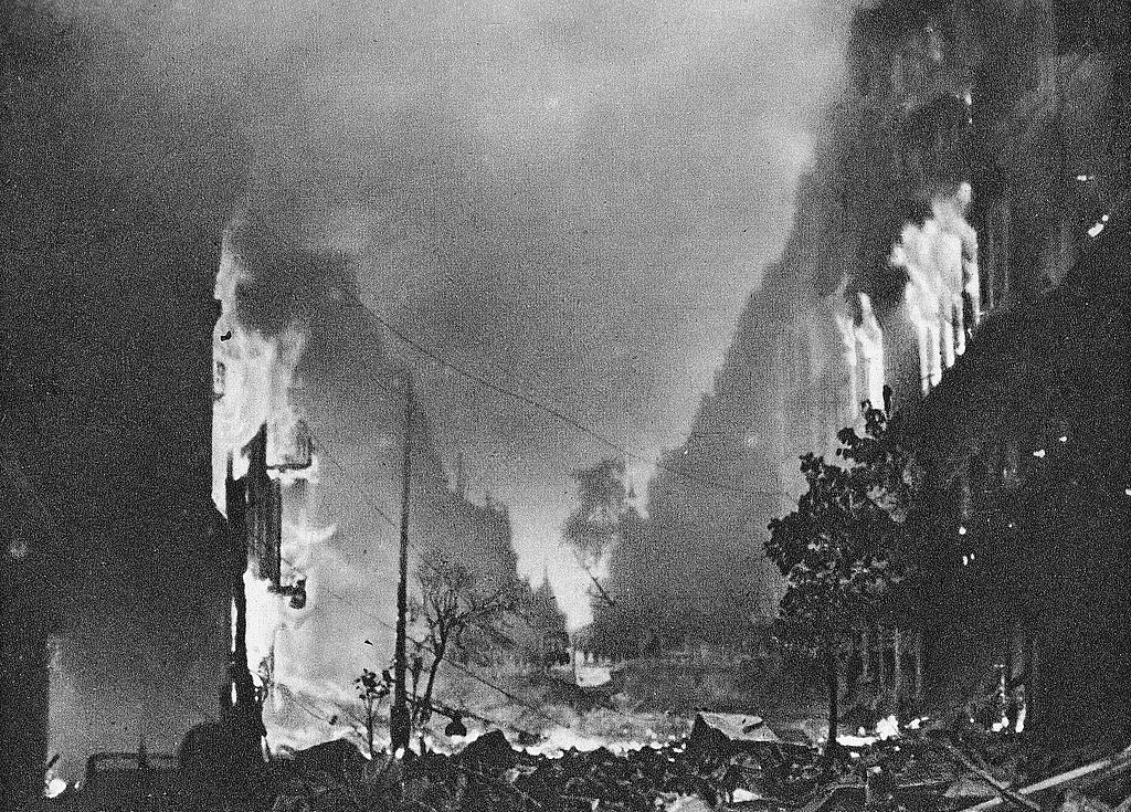 W czasie Powstania śmierć czyhała na każdym kroku. Ilustracja poglądowa przedstawiająca płonące domy na ulicy Marszałkowskiej (domena publiczna).