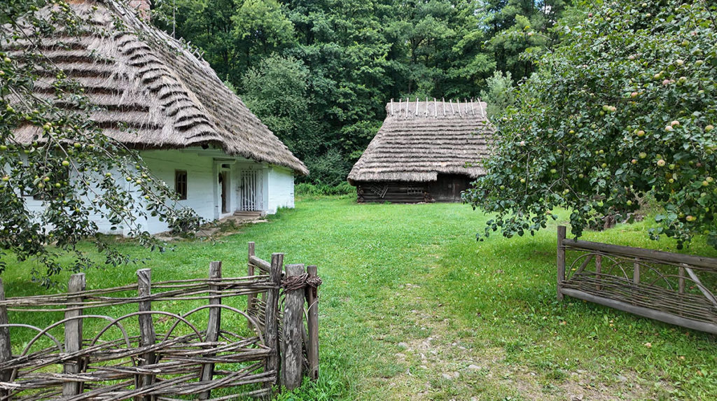 Zagroda chłopska z skansenie w Sanoku. Z lewej chata, z prawej - stodoła.