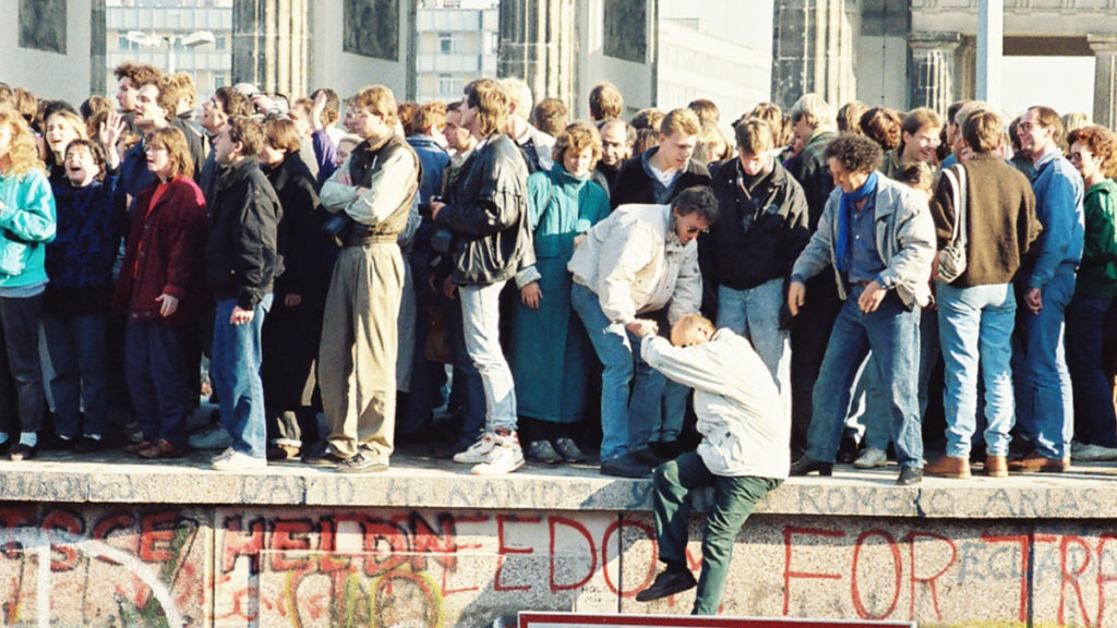Ludzie na szczycie muru berlińskiego 9 listopada 1989 roku