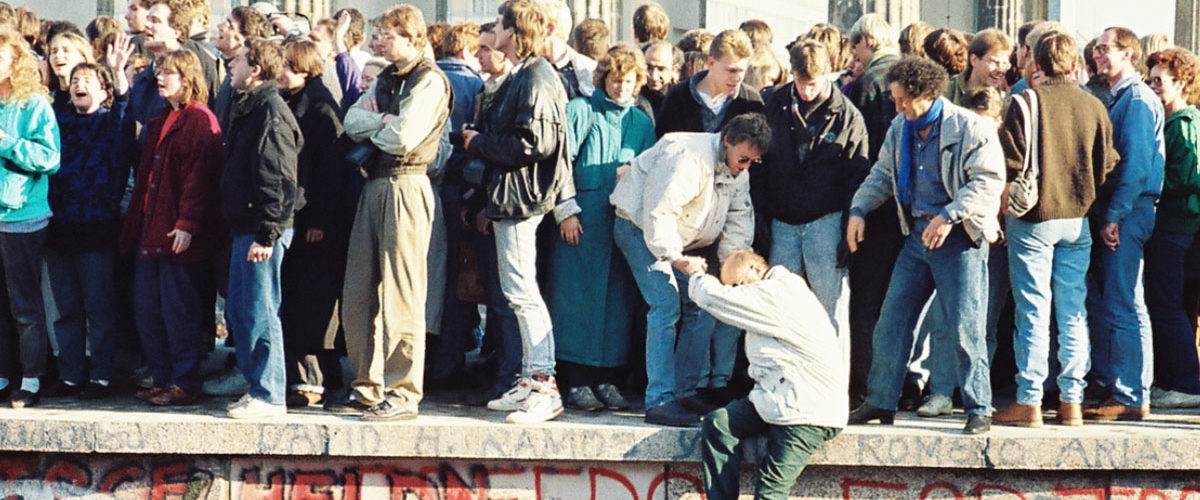 Ludzie na szczycie muru berlińskiego 9 listopada 1989 roku